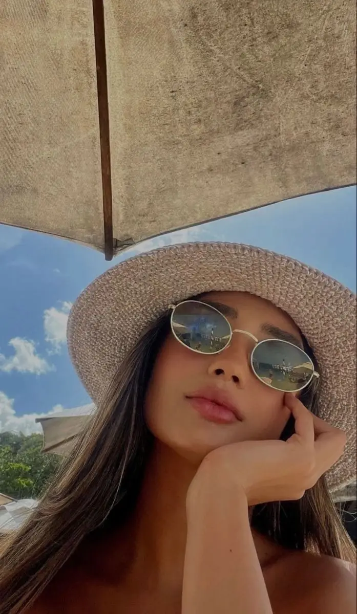 Woman under a sunshade outdoors.