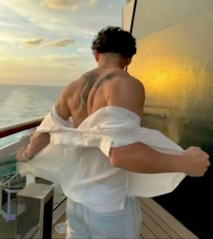 Man adjusting shirt by the ocean