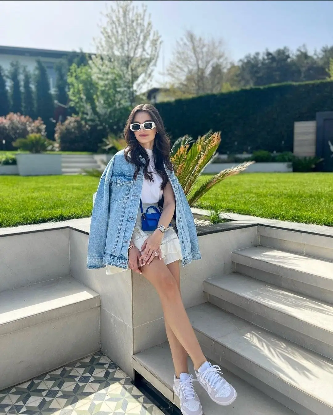 Woman in denim jacket on steps.